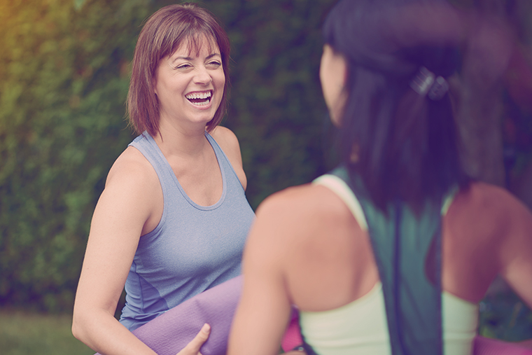 Two women talking before doing yoga in the summer