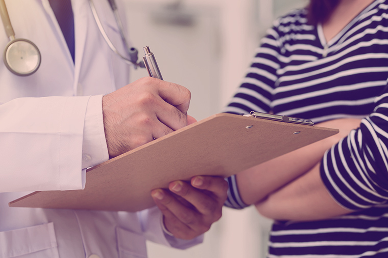 Doctor holding application form while consulting patient